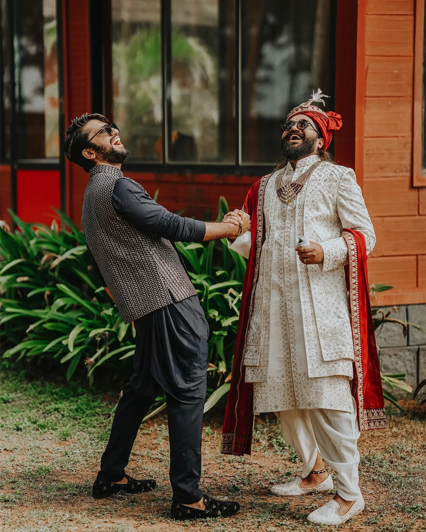 A groom and his friend laughing joyfully during wedding celebrations